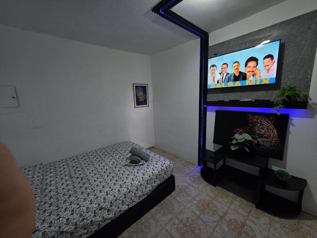 a bedroom with a bed and a flat screen tv at Relax en el pueblo 2 in Fajardo
