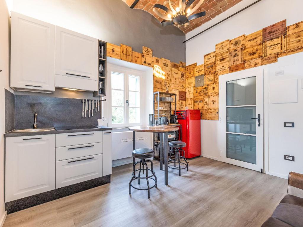 a kitchen with white cabinets and a table with stools at Apartment The Knight's Rest by Interhome in Bibbona