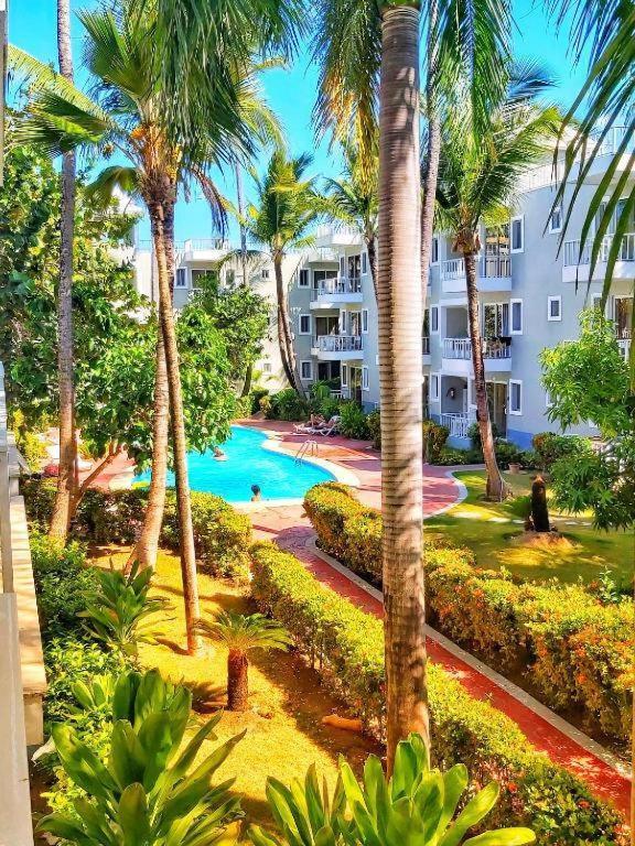 a view of a resort with a swimming pool and palm trees at beautiful vacation Sol Caribe in Punta Cana