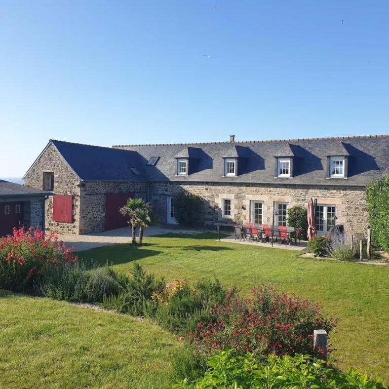 a large stone house with a yard at Le clos du Verdelet vue mer piscine in Planguenoual