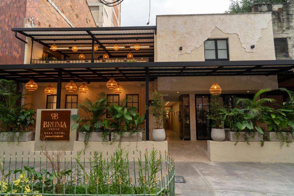 a restaurant with potted plants in front of a building at Bruma Verde Casa Hotel in Medellín