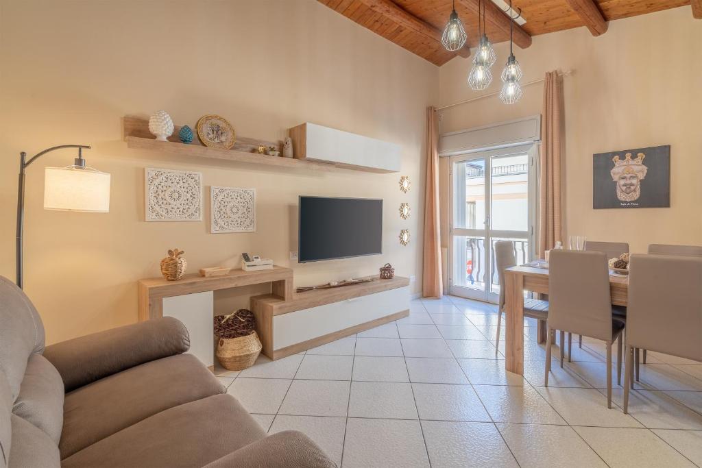 a living room with a television and a dining room at Le tre pigne in Floridia