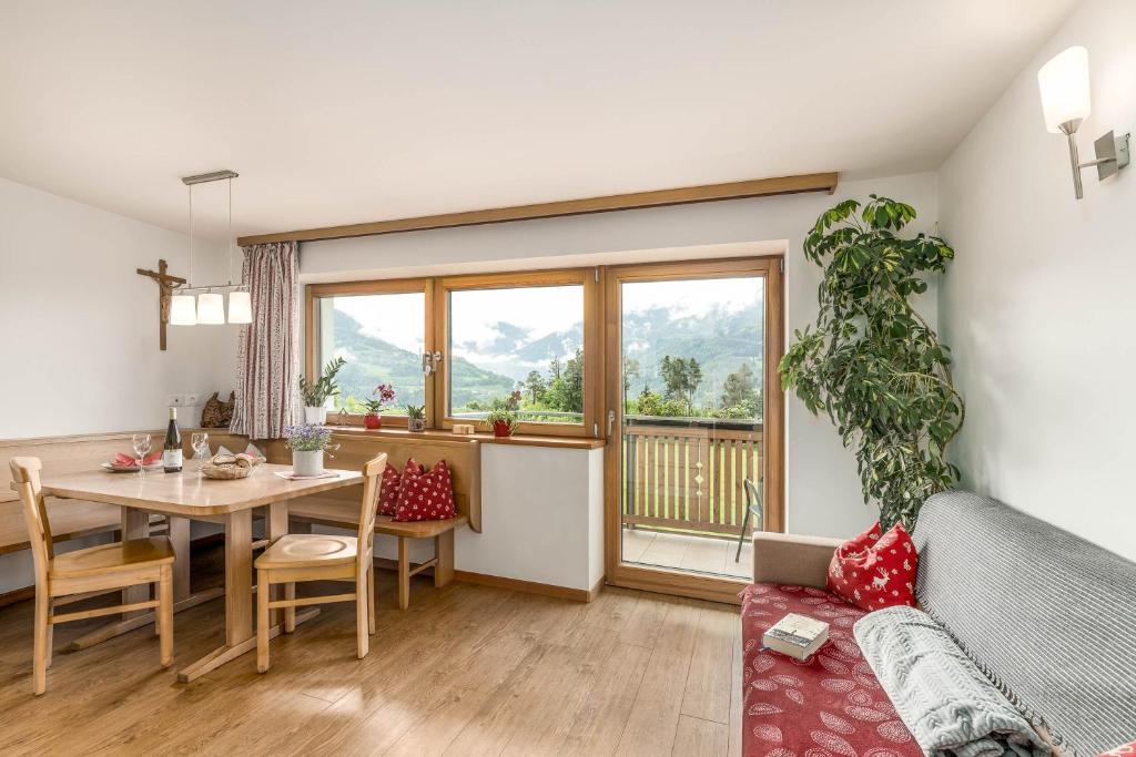 a living room with a table and a couch and a dining room at Huberhof App Golden Delicious in Feldthurns