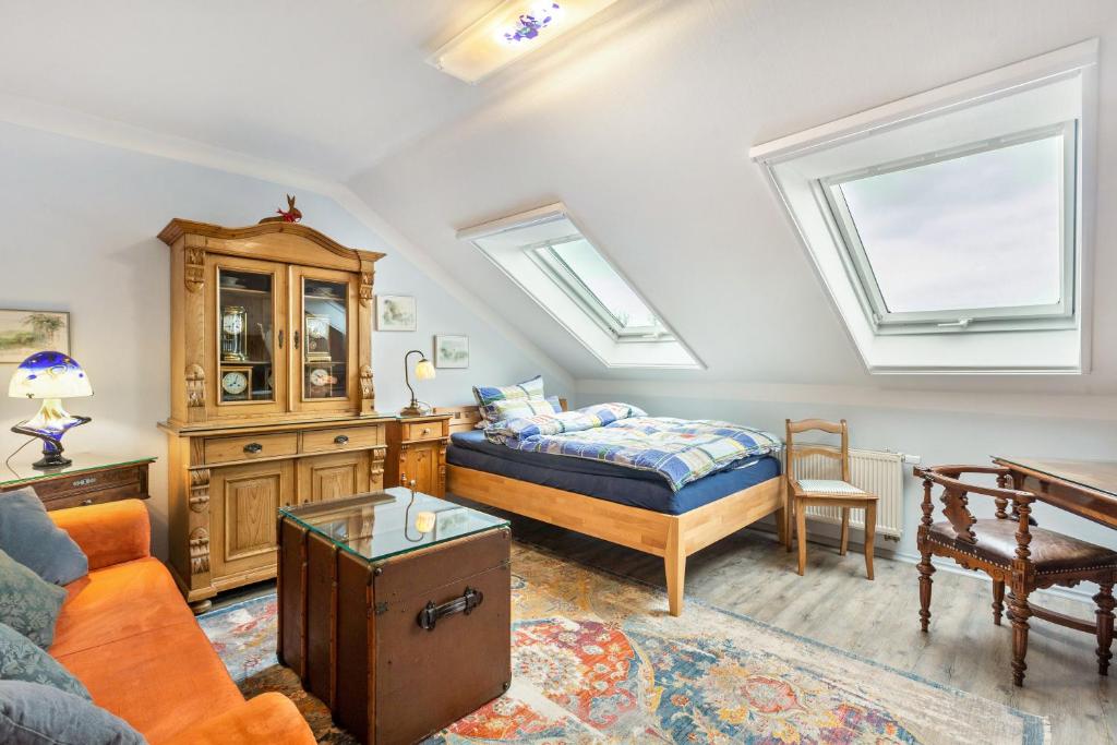 a bedroom with a bed and a couch and windows at Ferienwohnung Zur Henne in Weinbach