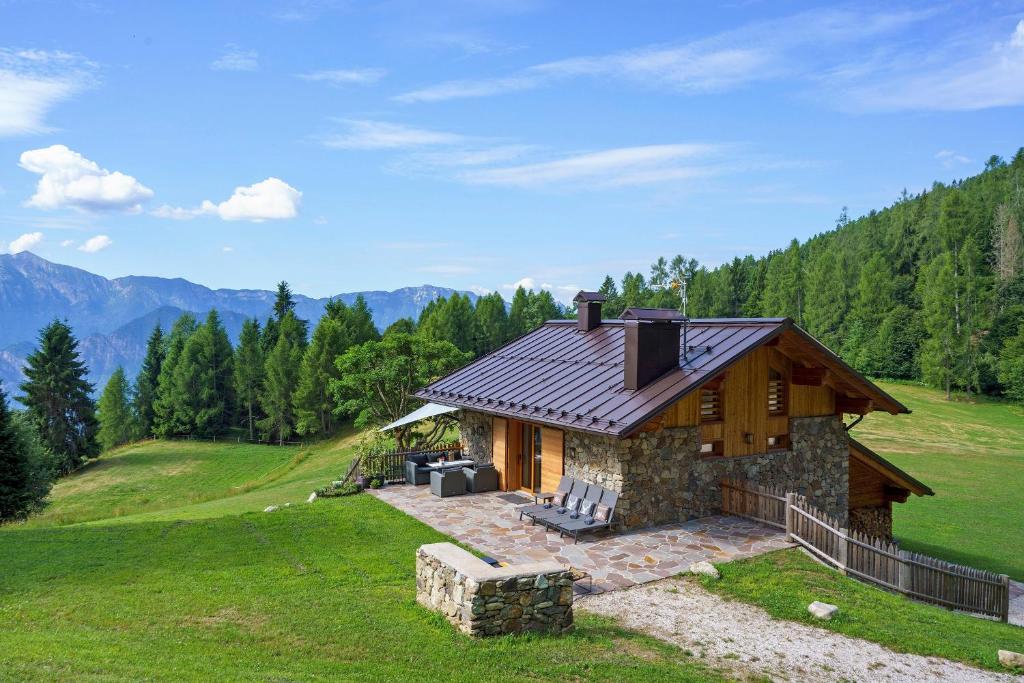 a small house on a hill with mountains in the background at Luxury Chalet Giulia in Torcegno
