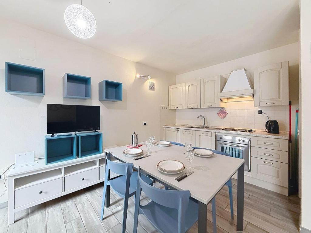 a kitchen with a table and blue chairs in a room at Apartment Marmolada-13 by Interhome in Alba di Canazei