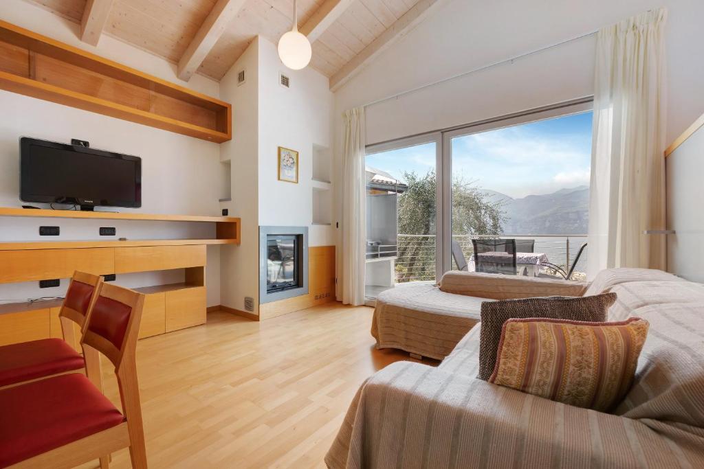 a living room with a large window and a tv at Casa-lago suite 55 in Brenzone sul Garda