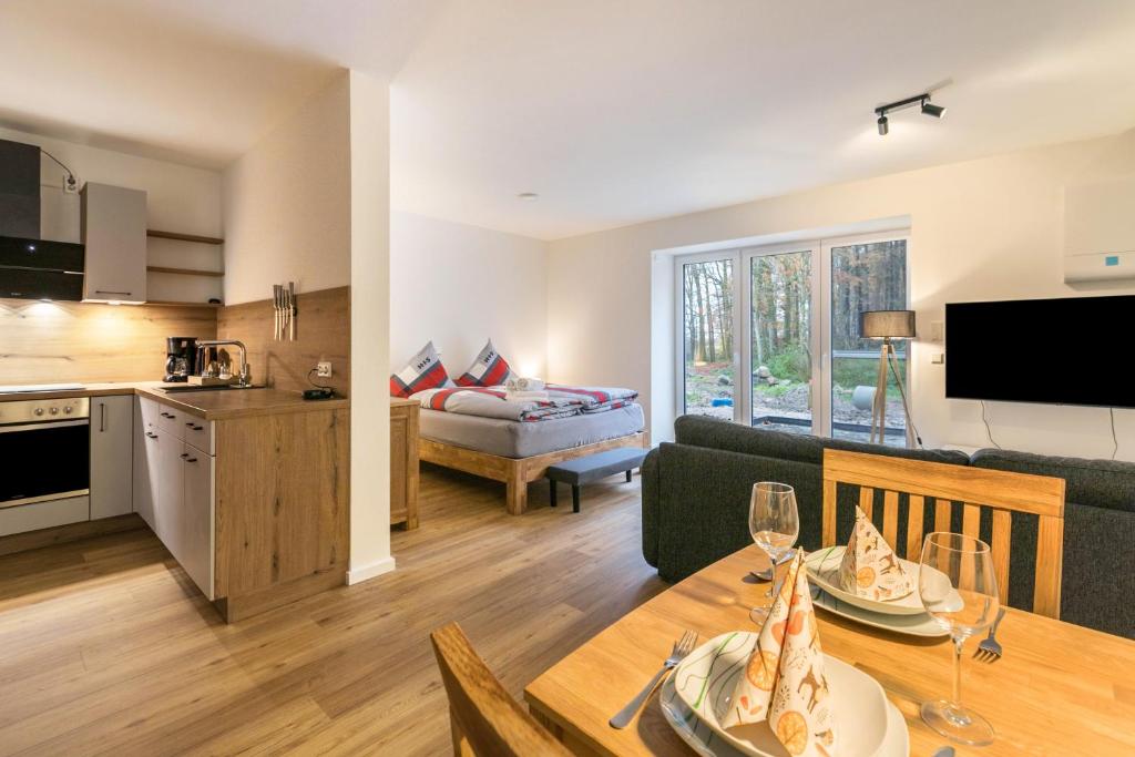 a kitchen and a living room with a dining table at Willewatt Wohnung 1 in Husby
