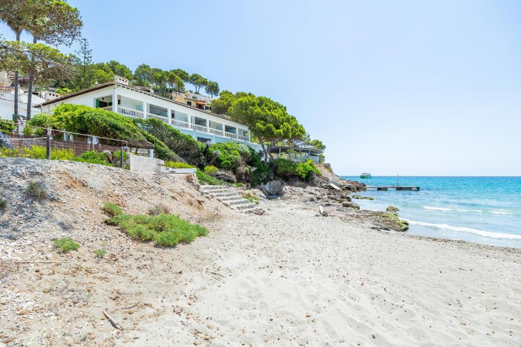 a house on the beach next to the ocean at Hostal Boutique Canyamel in Canyamel