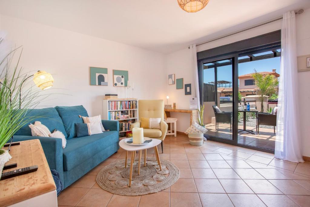 a living room with a blue couch and a table at Encantadora Casa Tara in Lajares