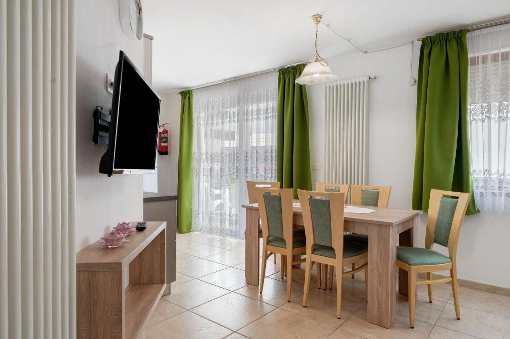 a dining room with a table and green curtains at Night and day 8 in Predazzo