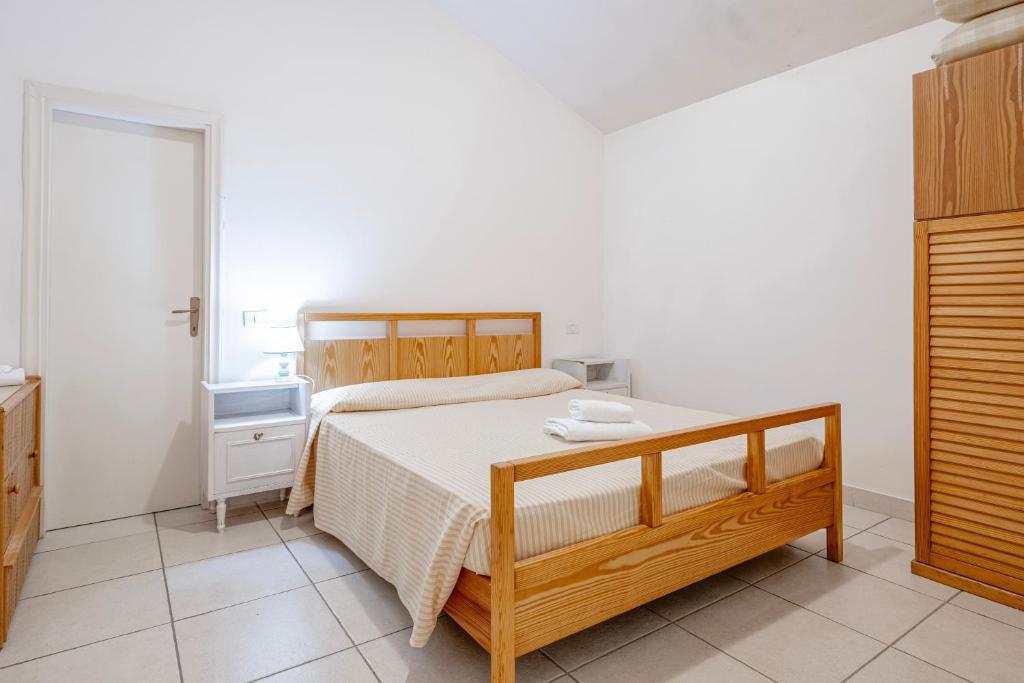 a bedroom with a wooden bed and a window at La Capannuccia D in Ansedónia