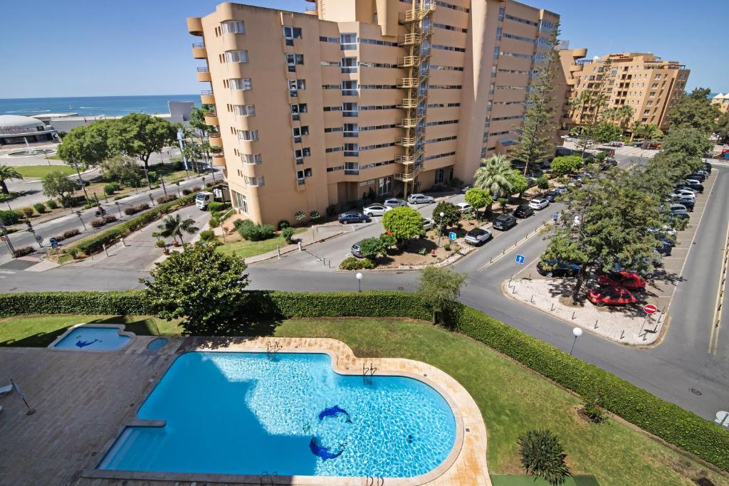 an overhead view of a swimming pool in front of a building at T2 com piscina centro Vilamoura in Vilamoura