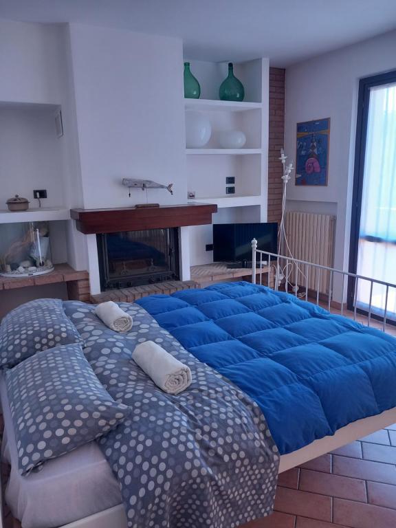 a large blue bed in a room with a fireplace at Villetta G in Senigallia