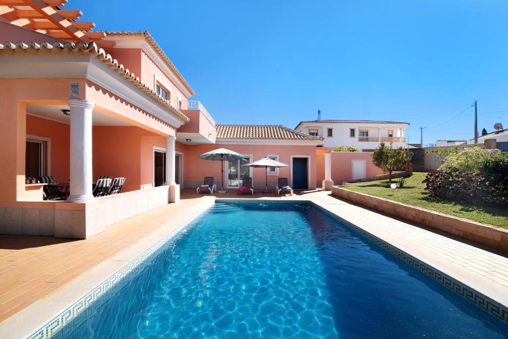 a swimming pool in the backyard of a house at Casa Tulipas in Loulé