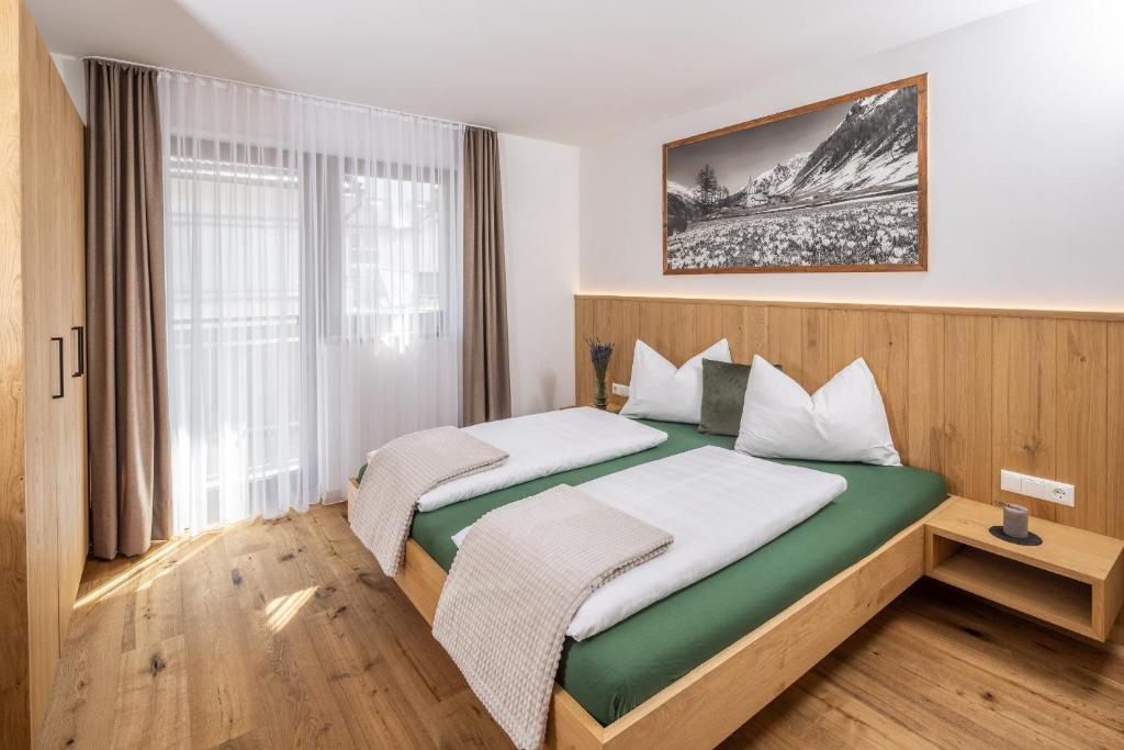 a bedroom with two beds and a large window at Zum Sonnentor App Larix in Lutago