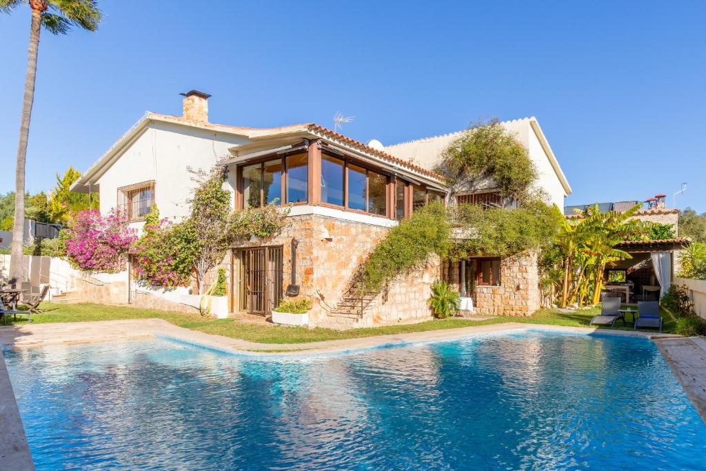 a house with a swimming pool in front of a house at Villa Relax en Benidorm in Salto de Agua