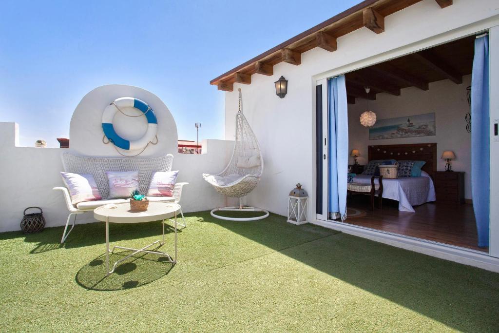 a patio with a room with a bed and a table at Vista Tostón in El Cotillo