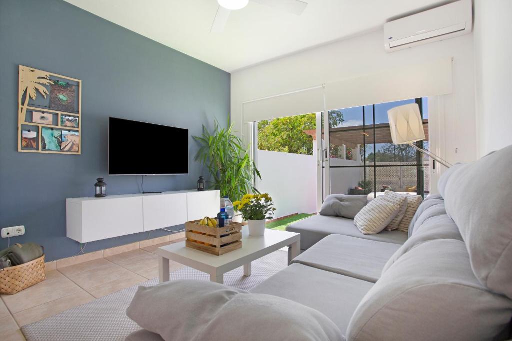 a living room with a couch and a tv at Apartamento 104 in Caleta De Fuste