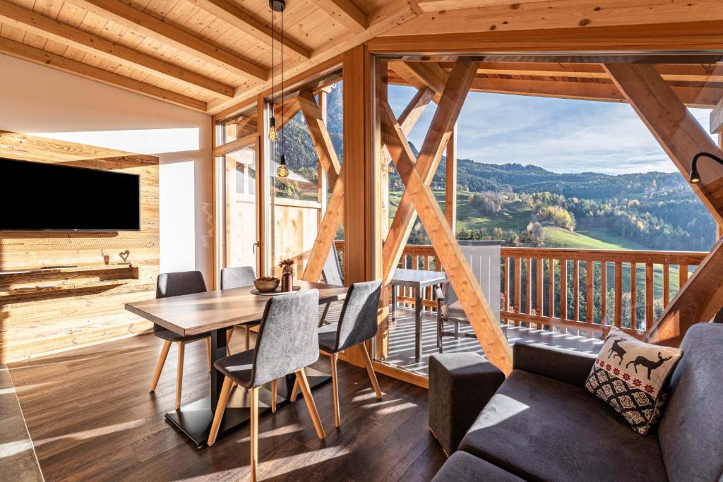 a dining room with a table and chairs and a large window at Zu Grof Morgenrot in Castelrotto