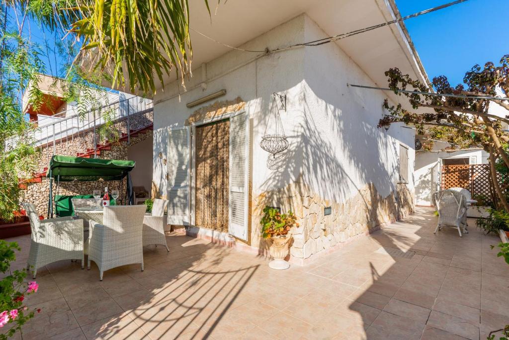 a white building with a table and chairs on a patio at Villetta a Torre Lapillo in Torre Lapillo