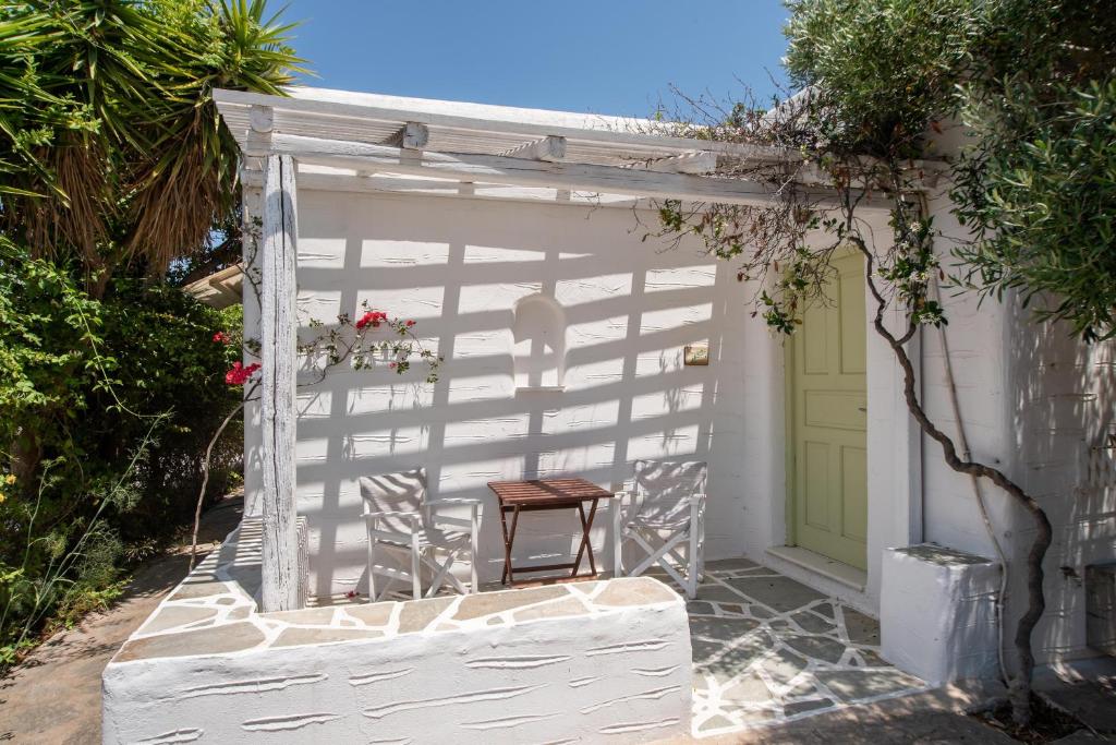 a wooden chair sitting inside of a white shed at Green Retreats 2 Paros in Isterni
