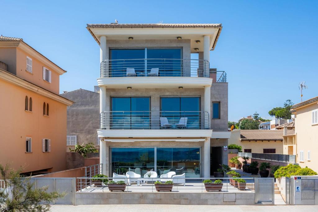 a large house with chairs on the balcony at Bohemi in Son Serra de Marina