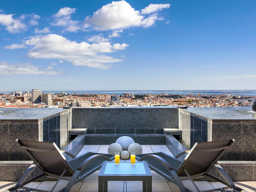 a dining room table with a balcony overlooking the ocean at Dom Pedro Lisboa in Lisbon