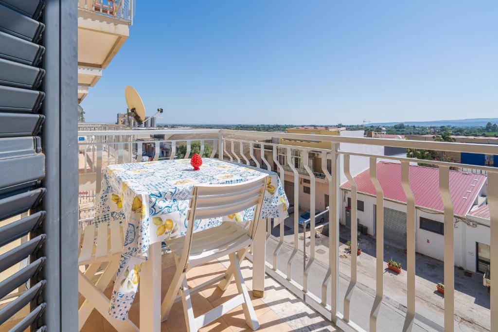 a table and chairs on a balcony with the ocean at A Casa Mia in Floridia