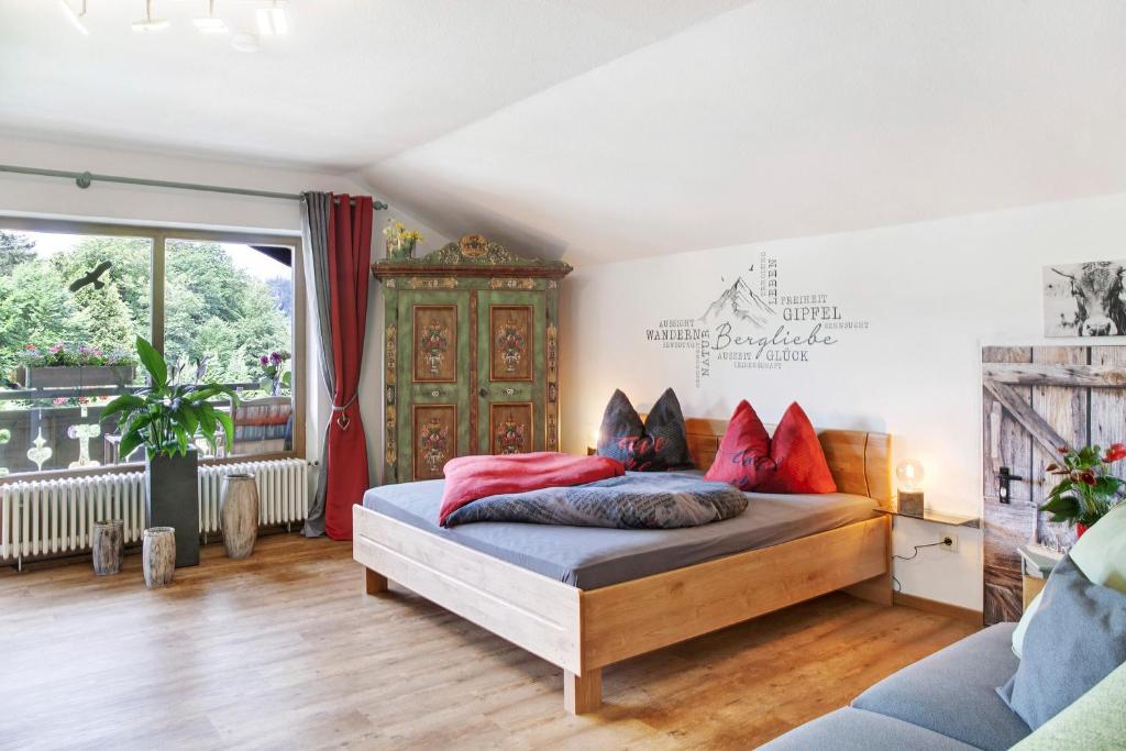 a bedroom with a bed with red pillows on it at Aschaubichl - Wohnung Anemone in Grainau