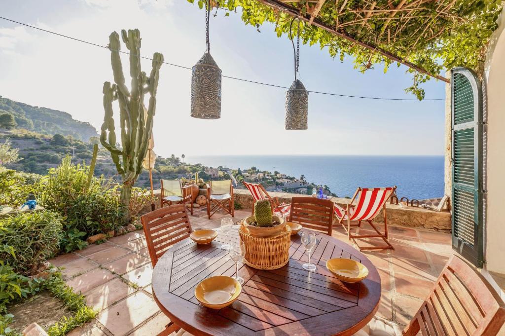 a patio with a table and chairs and the ocean at Can Sans in Banyalbufar