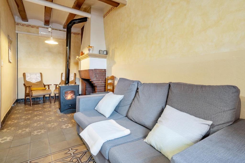 a living room with a couch and a fireplace at Ca Cedó in Serra de Almós