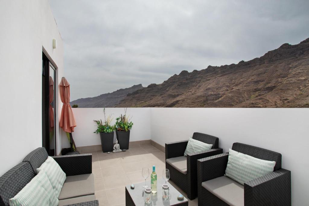 a living room with two chairs and a table at Dreaming Penthouse Mogan in Mogán