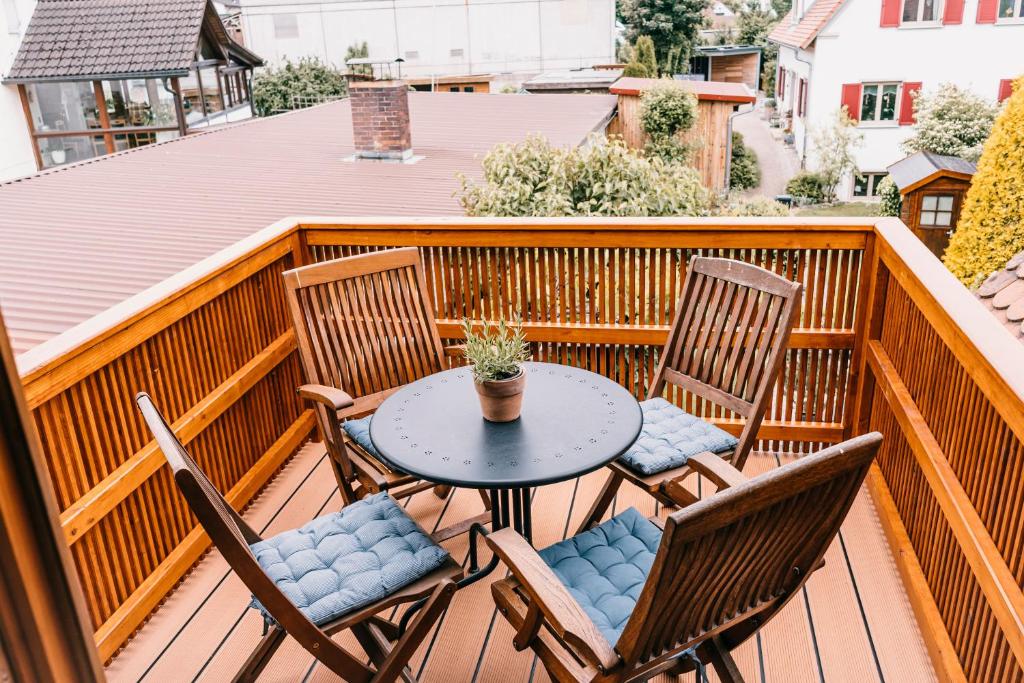 a patio with a table and chairs on a balcony at Ferienwohnung Alte Schneiderei in Heideck