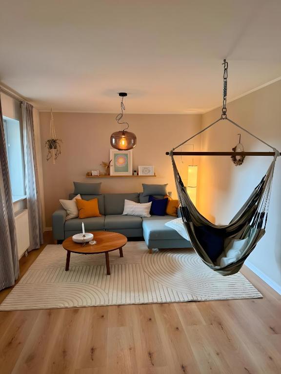 a hammock hanging in a living room with a couch at Lieblingszeit bei Bamberg in Hirschaid