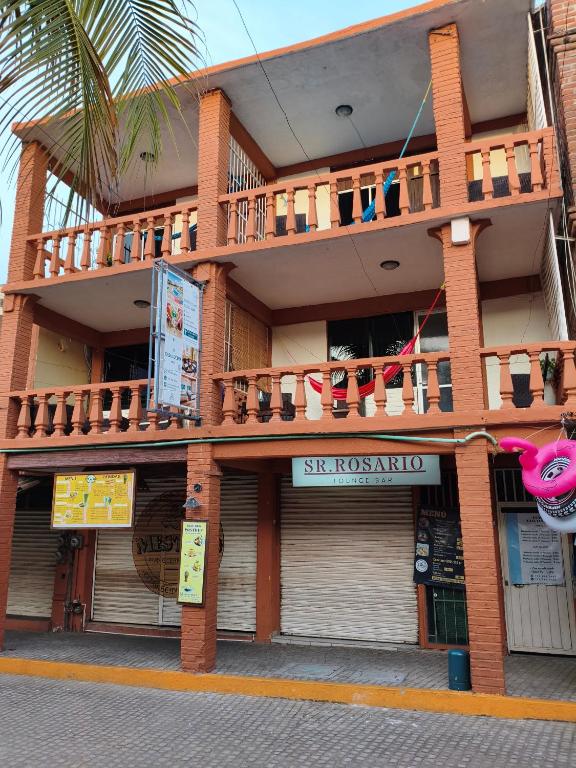 a building with a balcony on top of it at Hotel Casa Lucina in Zihuatanejo