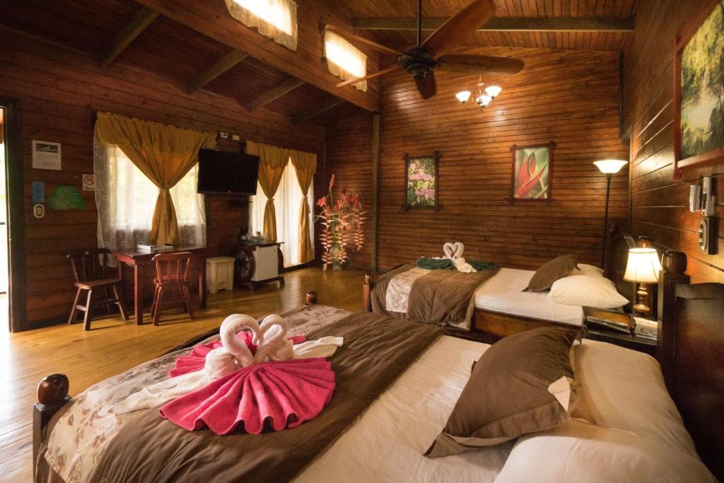 a room with two beds with dolls on them at Blue River Resort & Hot Springs in Liberia