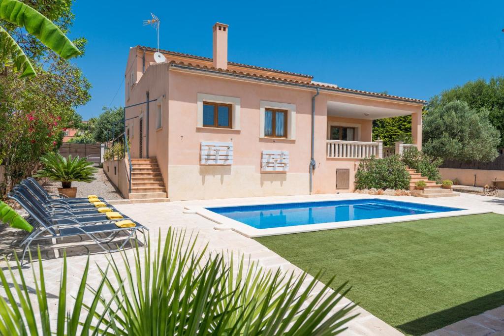 a villa with a swimming pool in front of a house at Can Fiol in Portocolom