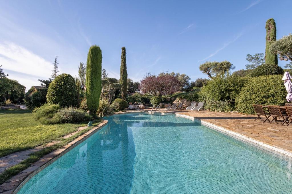 a swimming pool in a yard with trees at Casa Farigola in El Bruc