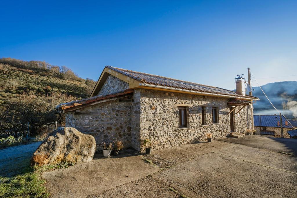 a stone house with a rock in front of it at Casa Lope in Dobres