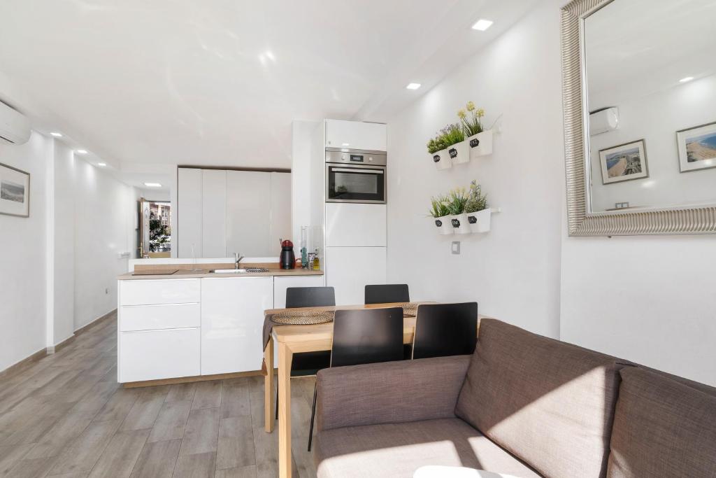 a kitchen and living room with a couch and a table at Los Molinos 202 in Maspalomas