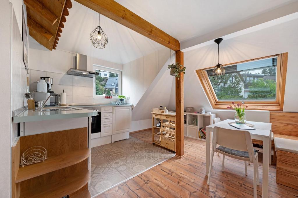 a kitchen with white cabinets and a table and a window at Fewo im Rosenberg mit Dachterasse in Lahnstein