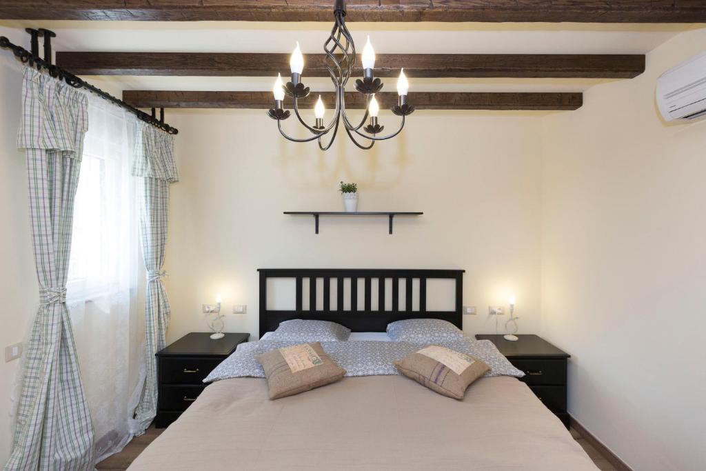 a bedroom with a bed and a chandelier at Villa Valeria in Rogoznica