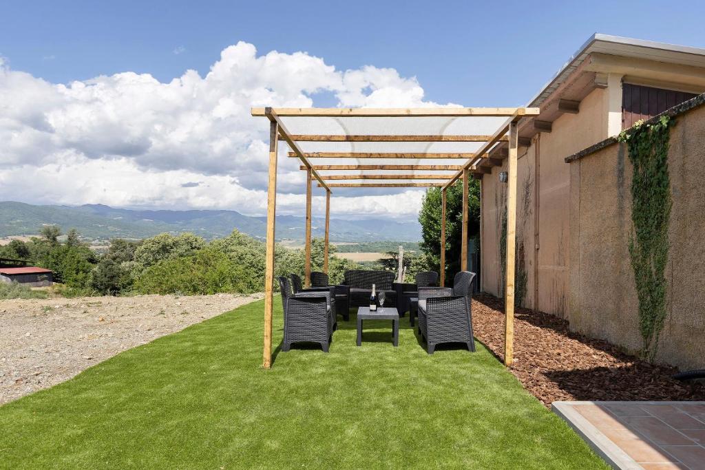 a patio with a table and chairs under a pergola at Bellavista Cottage in Barberino di Mugello
