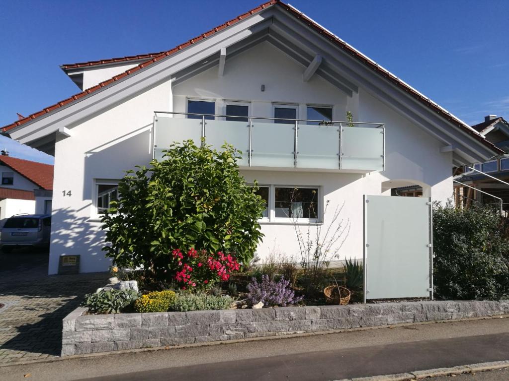 a white house with a balcony at Ferienwohnungen beim Imker in Mössingen