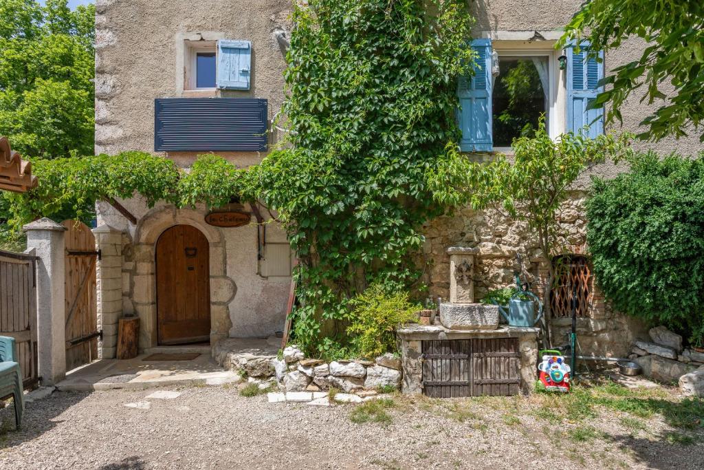 a stone house with a door and a tree at Appart Authentique et Confortable in Valderoure