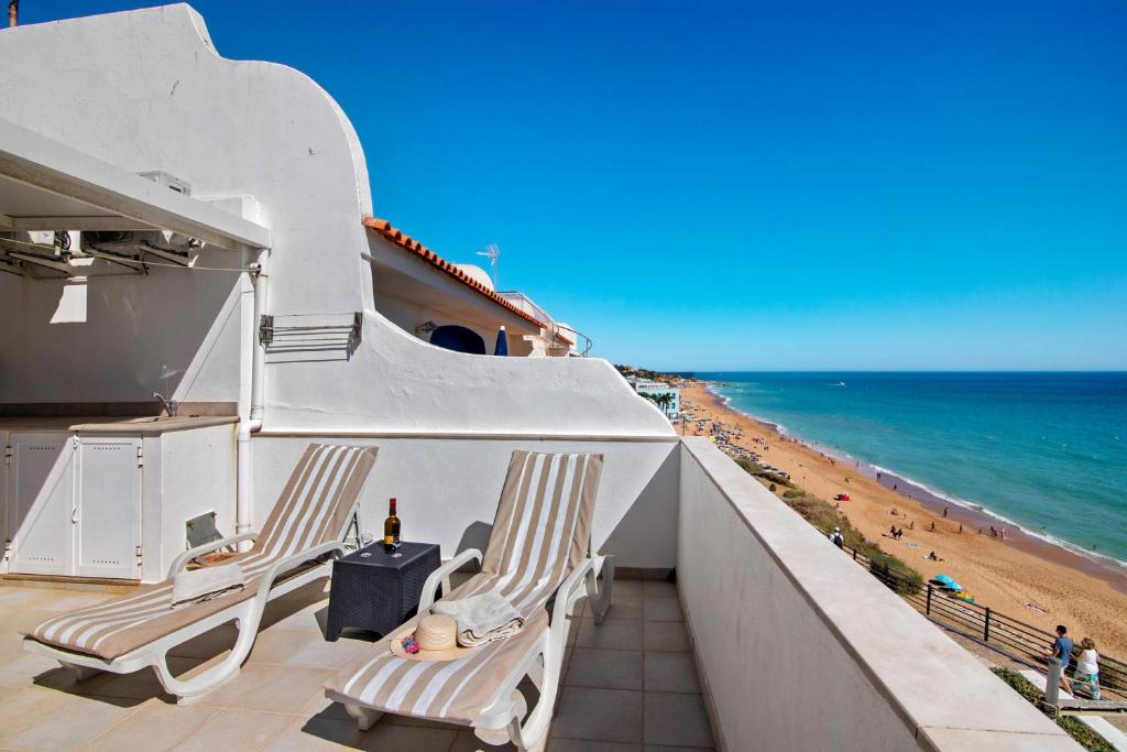 a balcony with two chairs and the beach at Casa Vista Mar in Albufeira