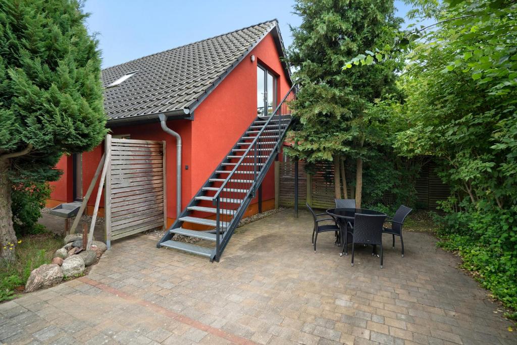 a red house with a staircase next to a table at Storchensommer in Blankensee