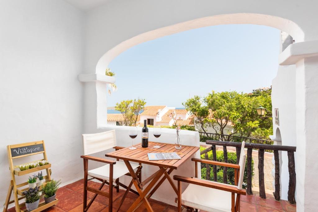 a dining room with a table and chairs on a balcony at Vistafaro in Es Mercadal