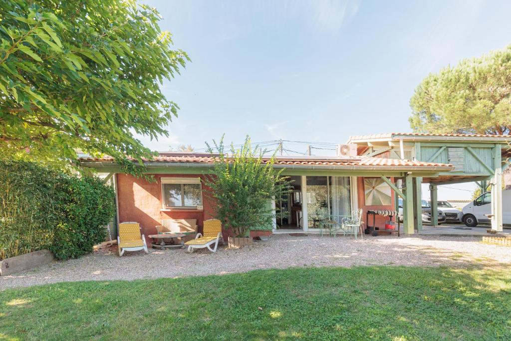 a small house with two chairs and a patio at Petit Havre Cosy Vue Pyrénénées in Estibeaux